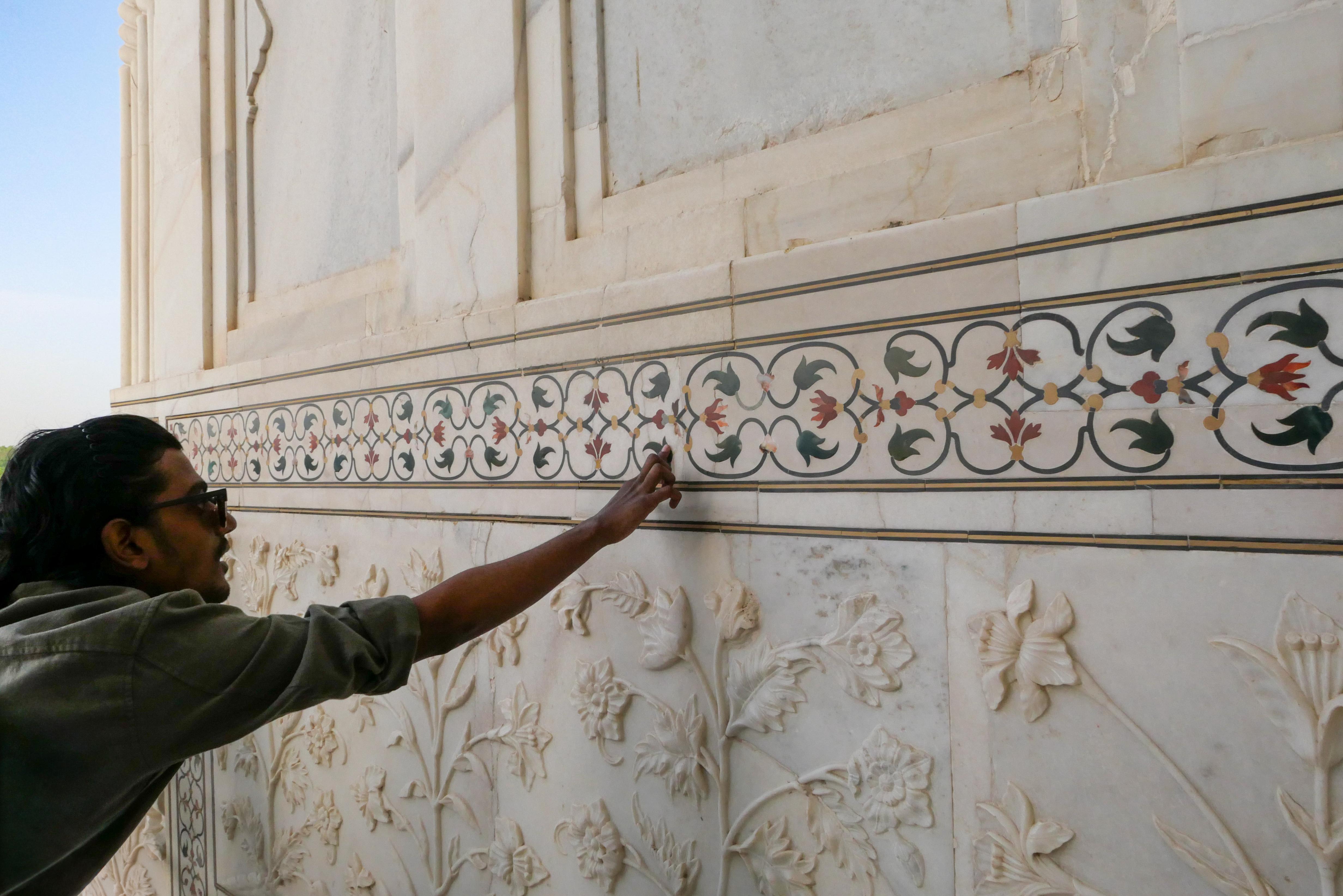 Guest exploring the intricate marble inlay artwork inside the Taj Mahal